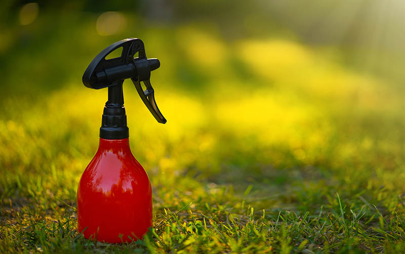 A red plastic spray gun on the grass