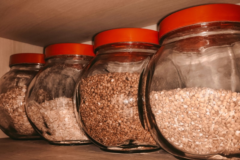 Assorted seeds stored in spearate jars on a shelf