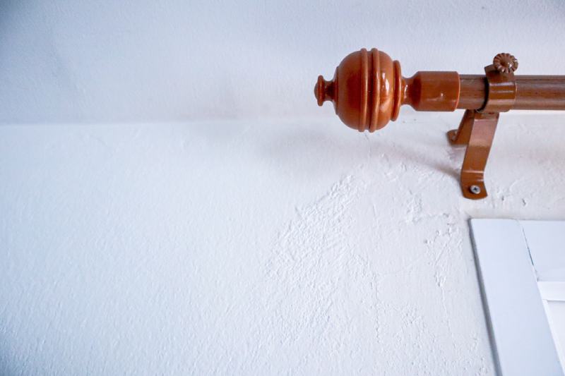 Brown curtain rod with white wall