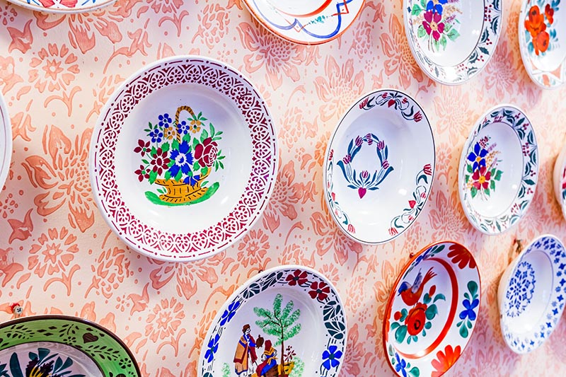Colored with flower design, ornamental plate is hanging on the wall