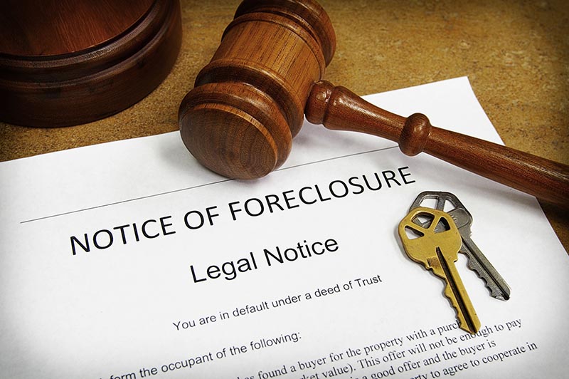Foreclosure document with house keys and gavel