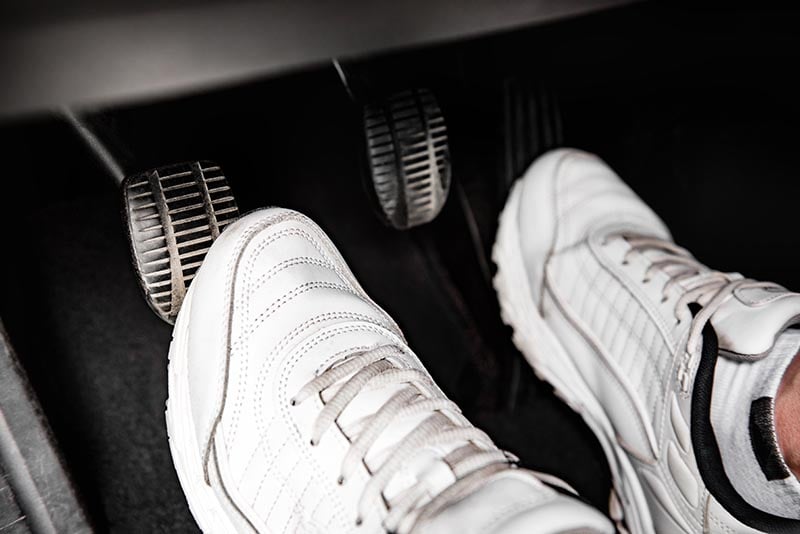 Human feet pressing car