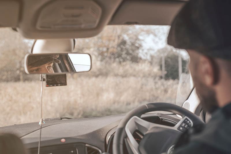 Image of a stylish man driving a right-hand drive car
