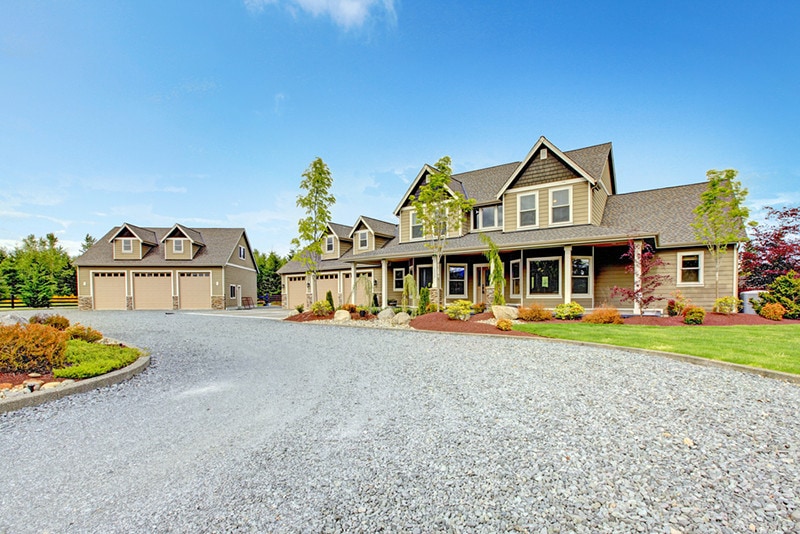 Large farm country house with gravel driveway and green landscape