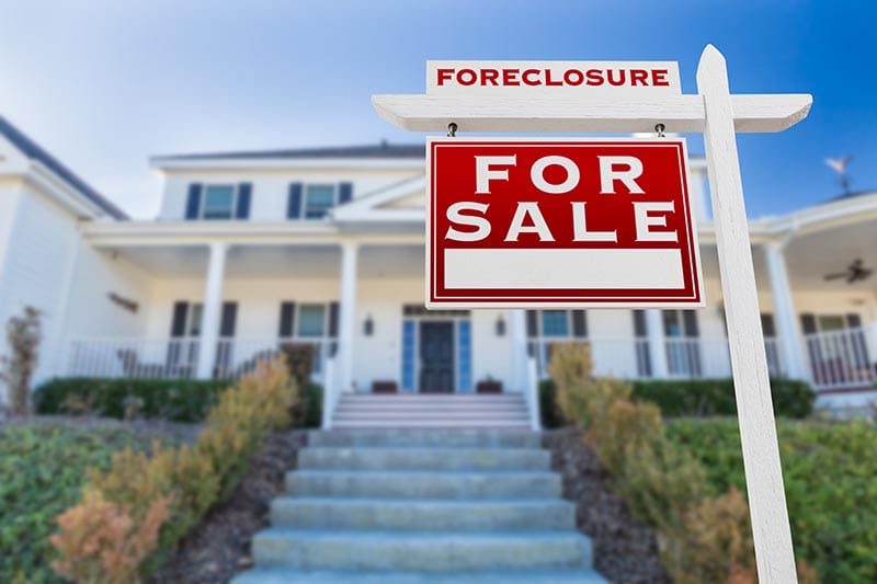 Left Facing Foreclosure For Sale Real Estate Sign in Front of House
