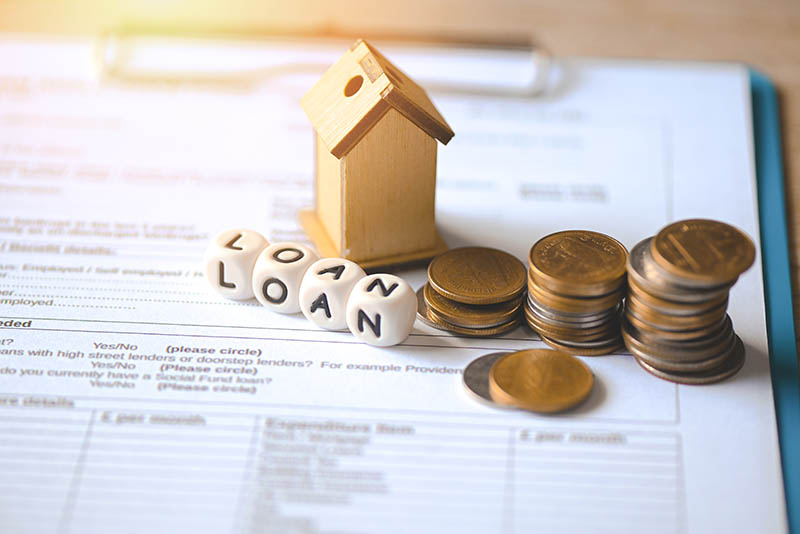 Loan application form paper with money coin and loan house model on table