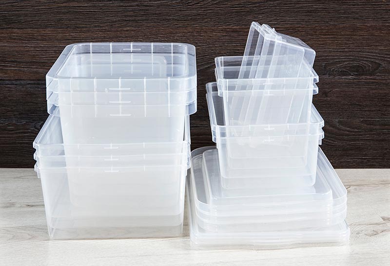 Lot of empty clear plastic storage boxes stacked