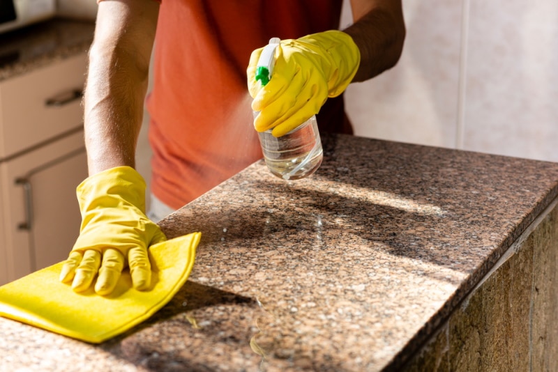 Man cleaning granite countertop
