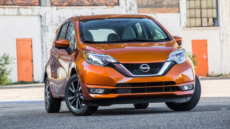 Metallic orange Nissan Versa parked on the road side
