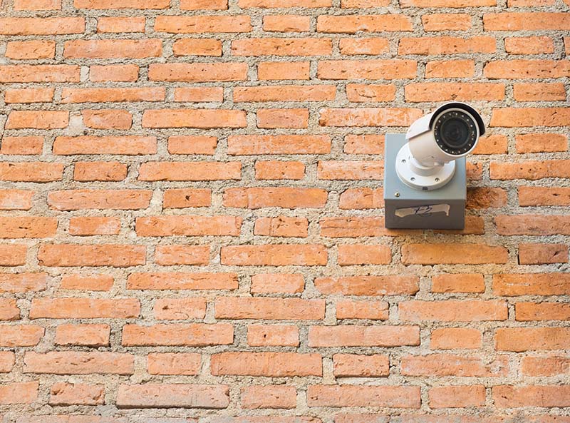 One closed circuit camera on brick wall
