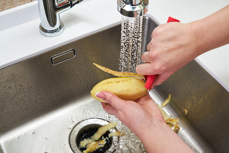 Peeling potato over Food waste disposer machine