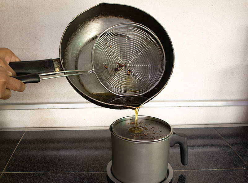 Pour the used cooking oil into the contaminated cooking oil container