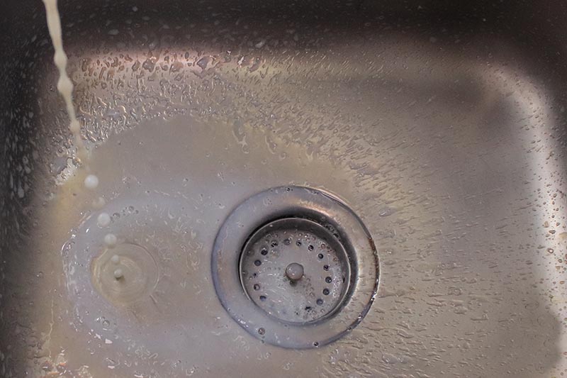 Pouring millk down the drain