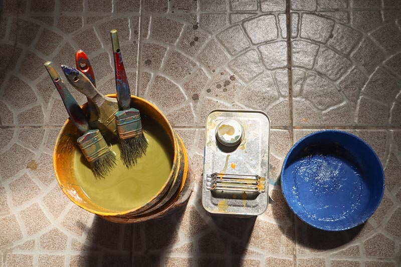 The old paint brush has been used and then soaked in a clean container with a thinner can