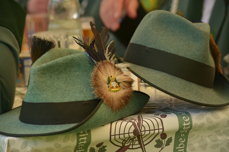 Two green fedora hats on a table