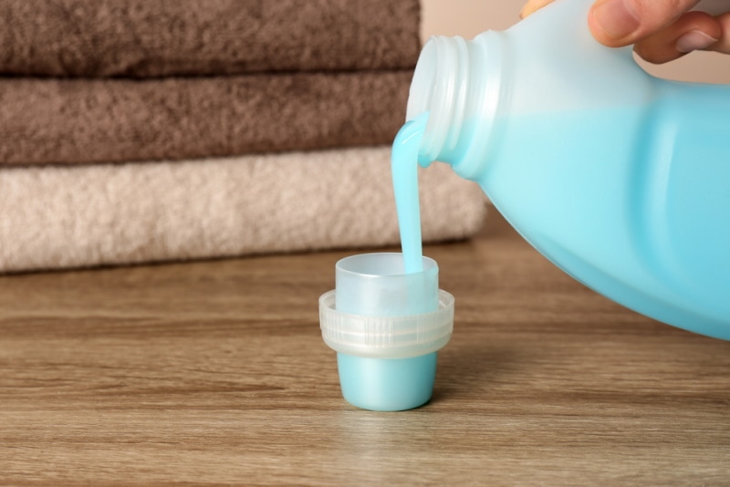 Woman pouring fabric softener into cap