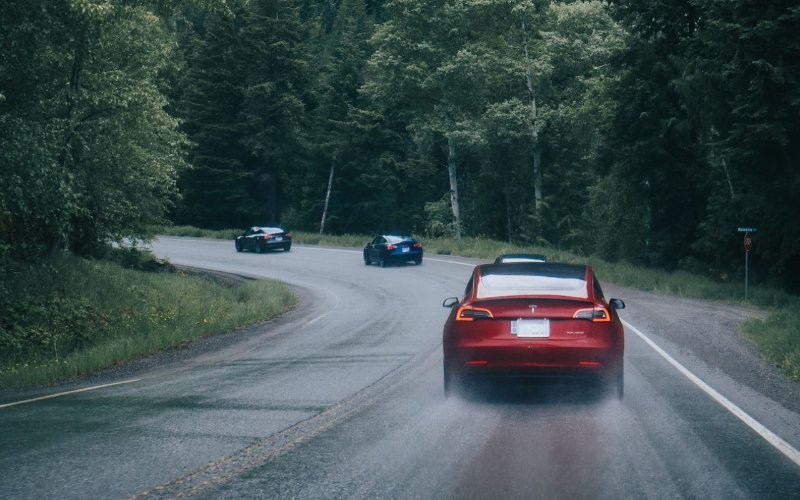 a group of Tesla cars driving down the road
