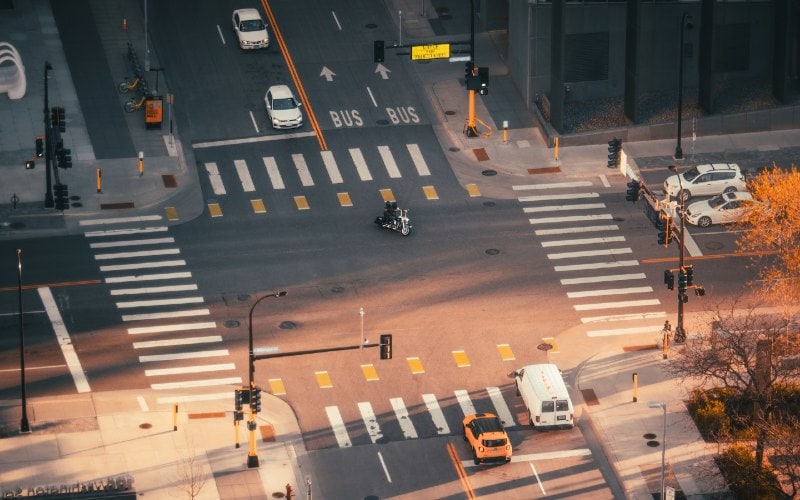 an intersection with cars, people, and traffic lights
