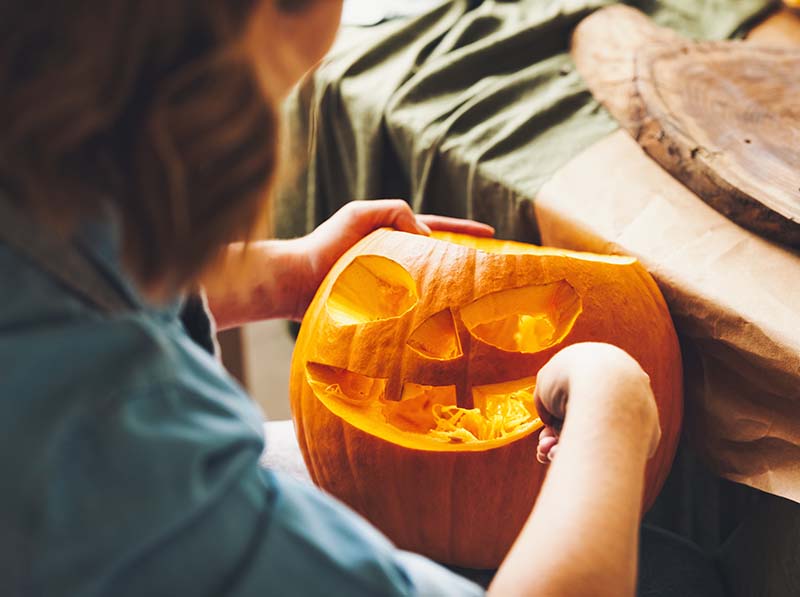 carving large orange pumpkin for Halloween party