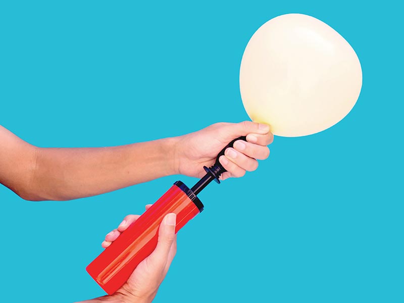 hand holding air balloon pumping
