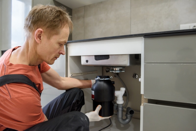 man checking garbage disposal
