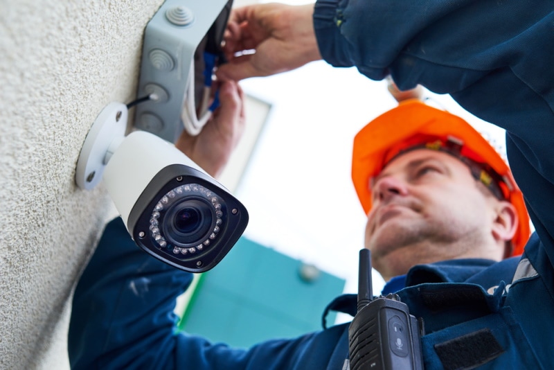 man fixing security camera