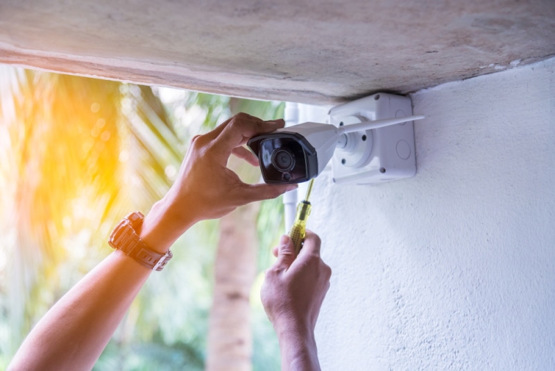 man installing security camera