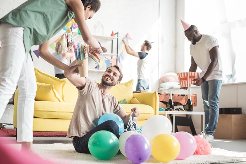 man on the floor with balloons