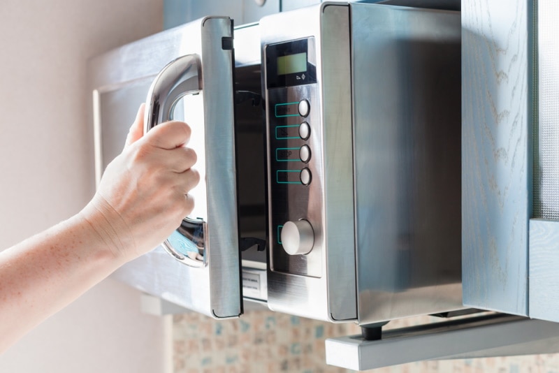man opening microwave oven