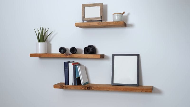 minimalist floating shelf made of wood with books and a picture on it
