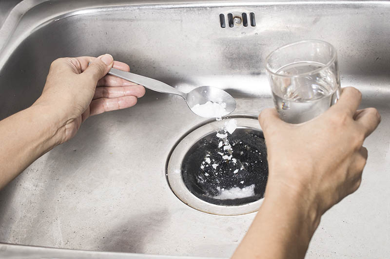 pour a spoon of baking soda and a glass of vinegar respectively into the drain of sink