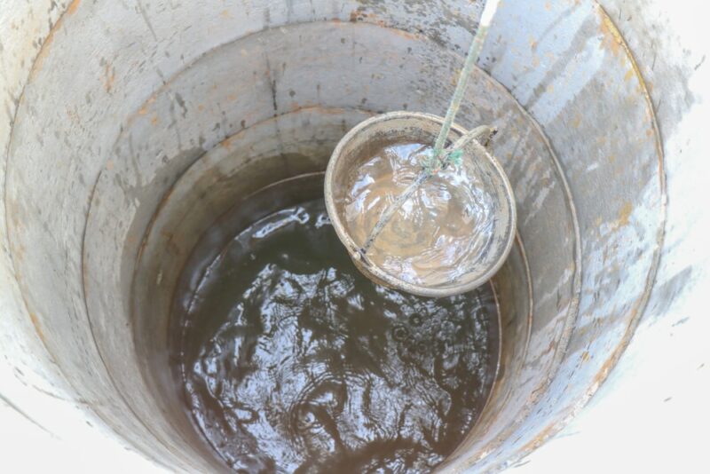 pulling out bucket full of drink water from the well