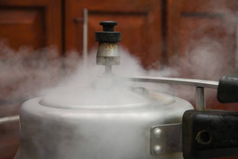 Steam escaping from lid of pressure cooker