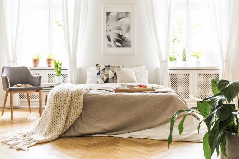 stylish bedroom interior with natural light coming through big windows