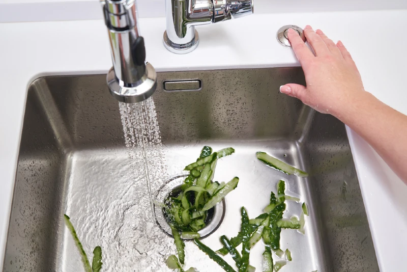 using the garbage disposal to break down food scraps with running water