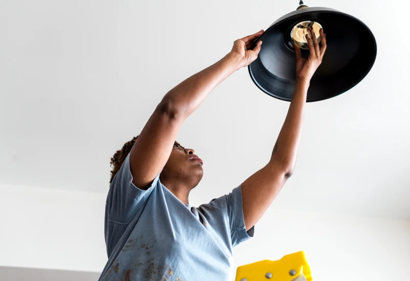 woman changing a light bulb