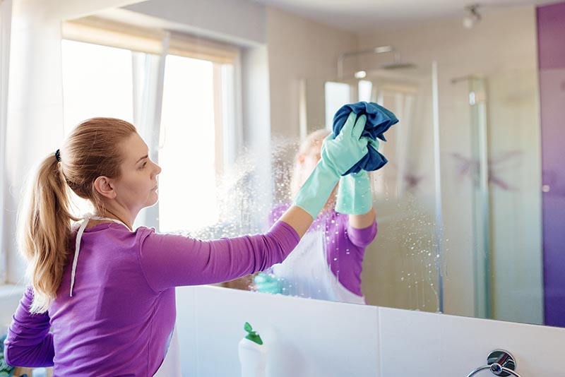 woman cleaning mirror