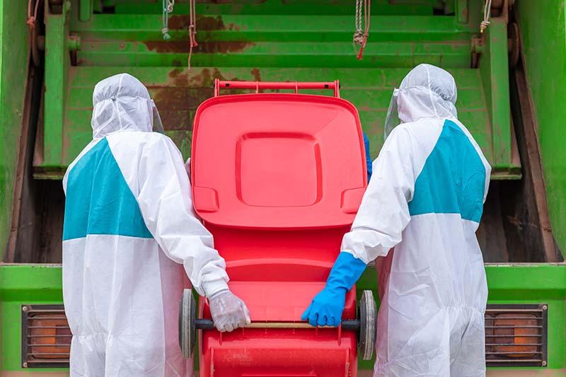 workers wearing PPE handling chemical waste