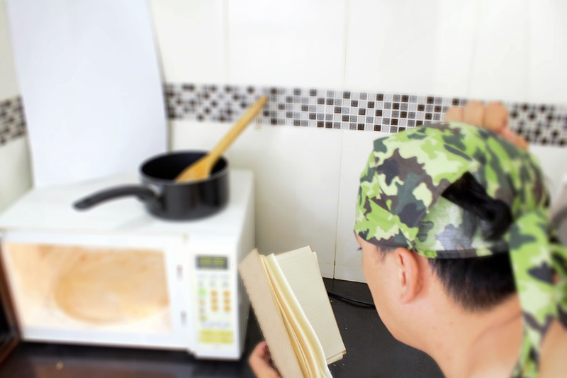 Chef reading microwave instruction manual