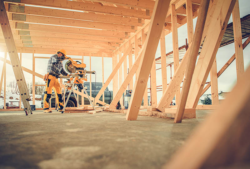 Contractor Carpenter Worker Using Commercial Grade Circular Saw in Construction Zone