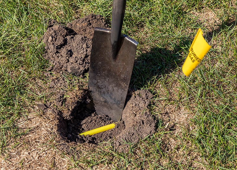 Hole in yard with yellow plastic natural gas