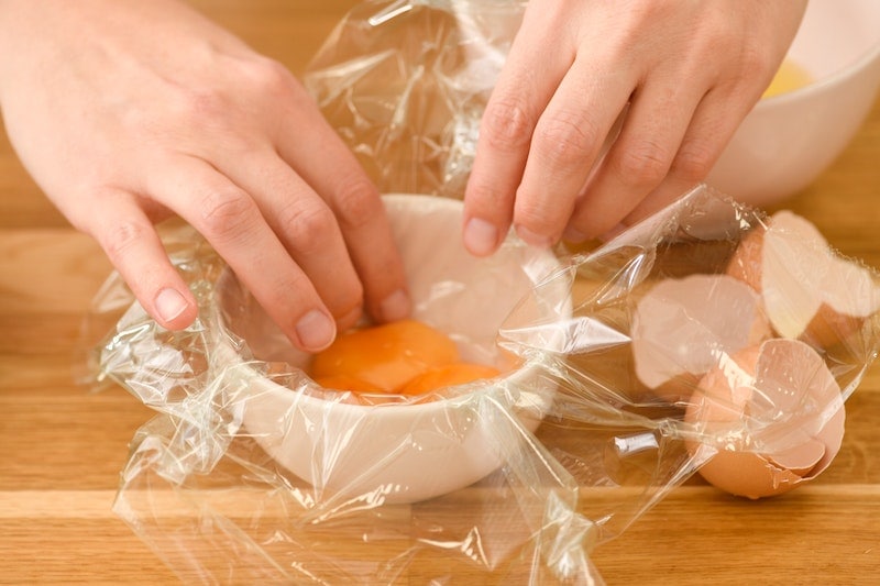 Person using Sarap wrap covering a bowl with egg