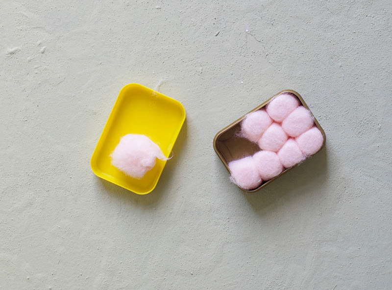 Traditional pink soft wax earplugs covered in cotton buds