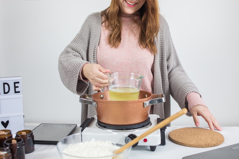 Woman making candle using double boiler method