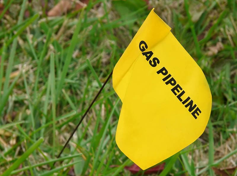 Yellow flag marking underground natural gas line in yard