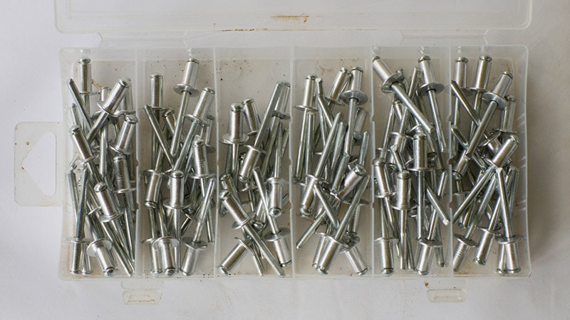 a plastic container of steel pop rivets