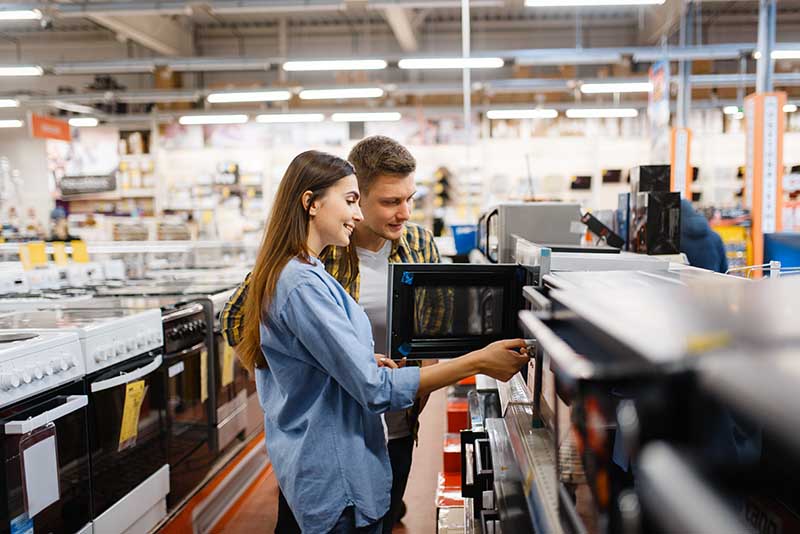 choosing a microwave in an electronics store