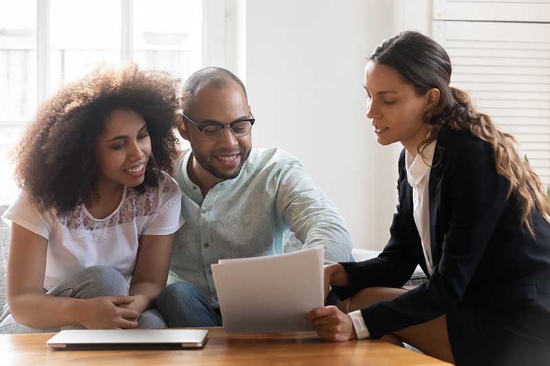couple discussing contract with realtor