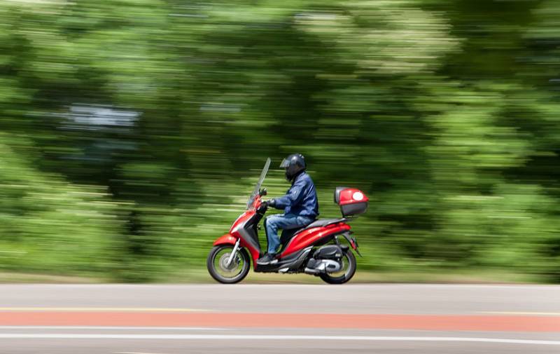 driver riding red moped