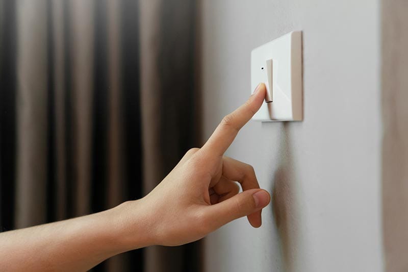 female finger turning on lighting switch